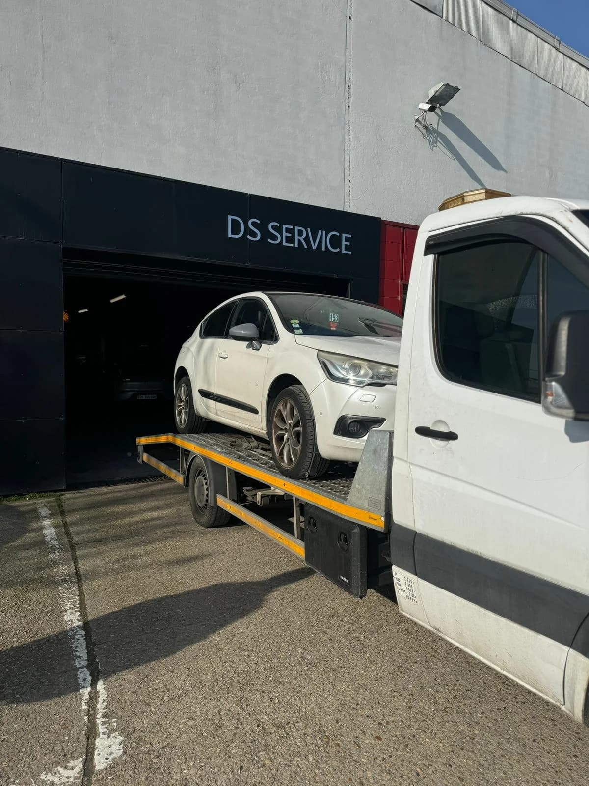 Livraison d'un véhicule devant un atelier de réparation